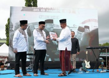 Edi Damansyah menyerahkan memori jabatan kepada Bupati Kukar Aulia Rahman Basri, didampingi Rendi Solihin, dalam acara serah terima jabatan di Masjid Agung Tenggarong, 30 Juni 2025.